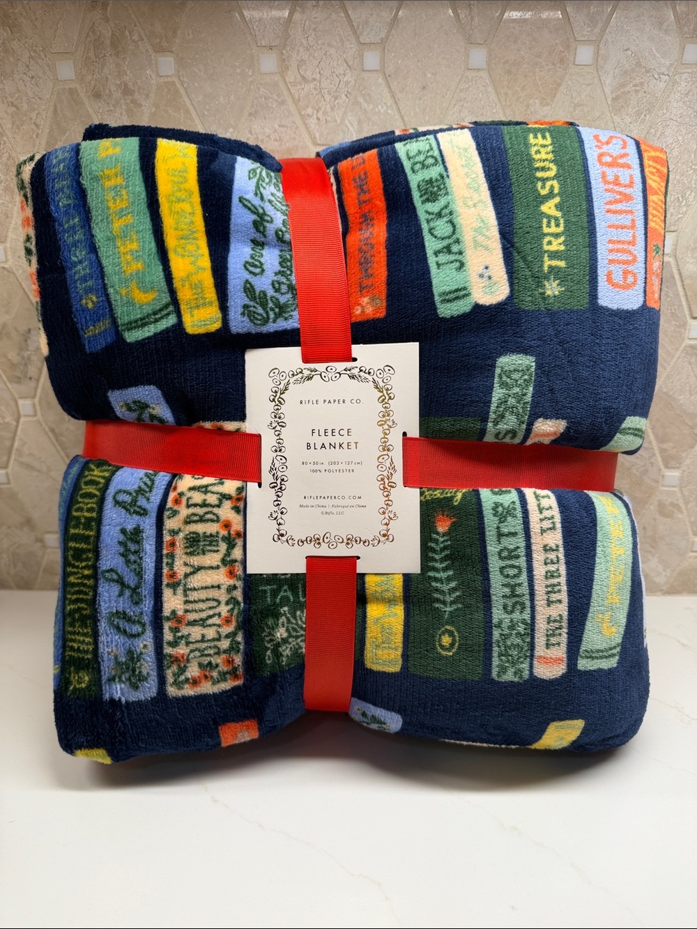 Rifle Paper Co. Navy Fleece Throw with Colorful Book Spine Print